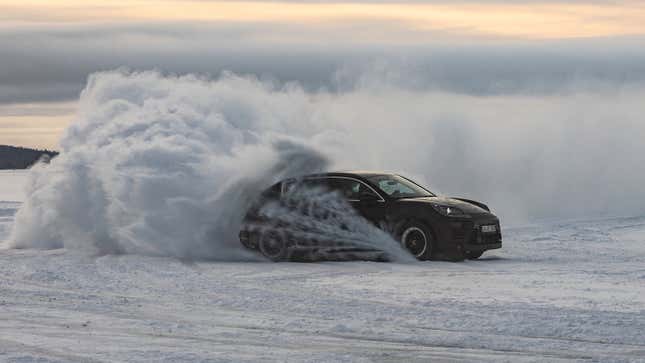 雪上を走行する電動ポルシェ マカン SUV の写真。 